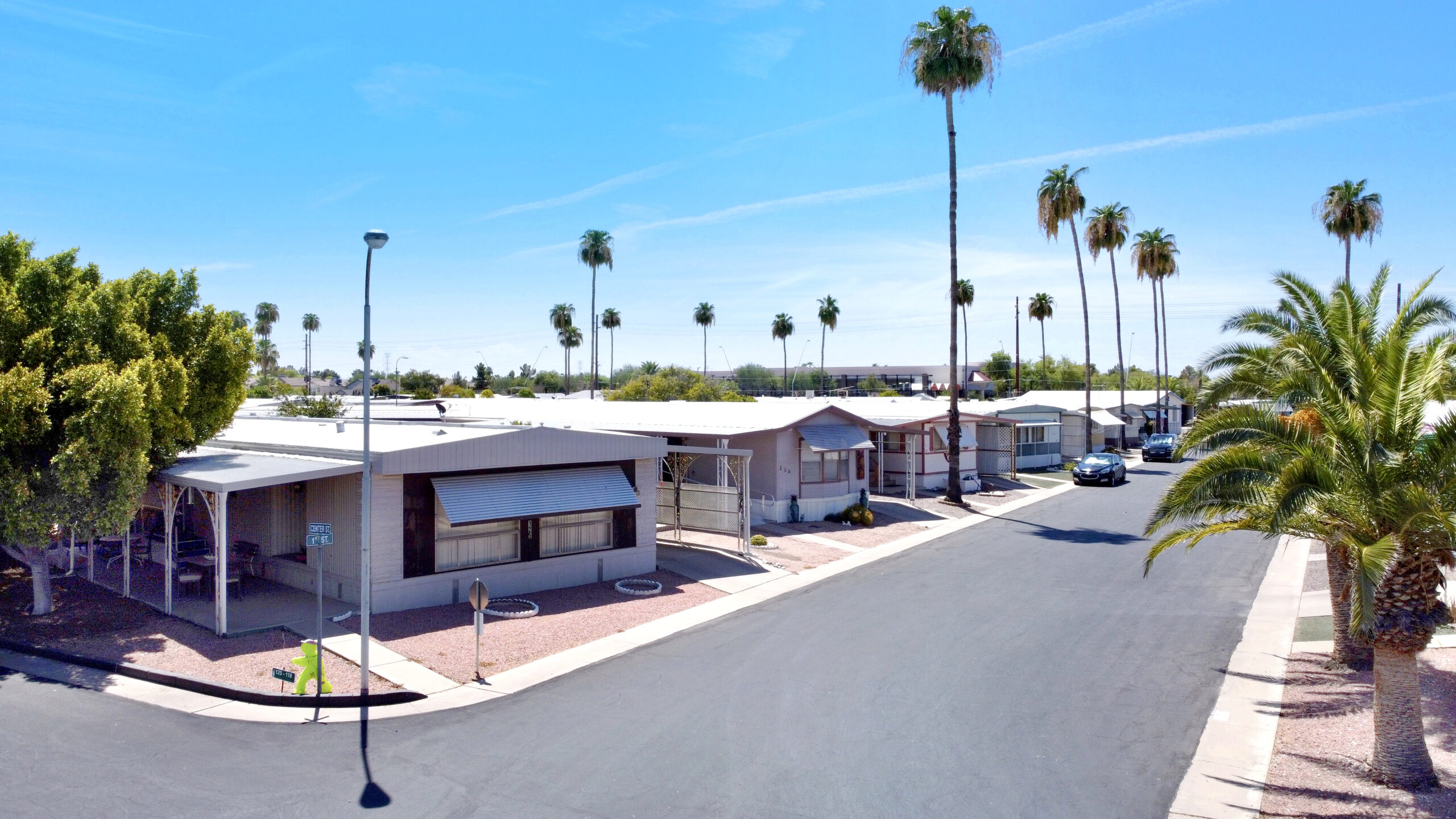 Street of manufactured homes under the shade of palm trees