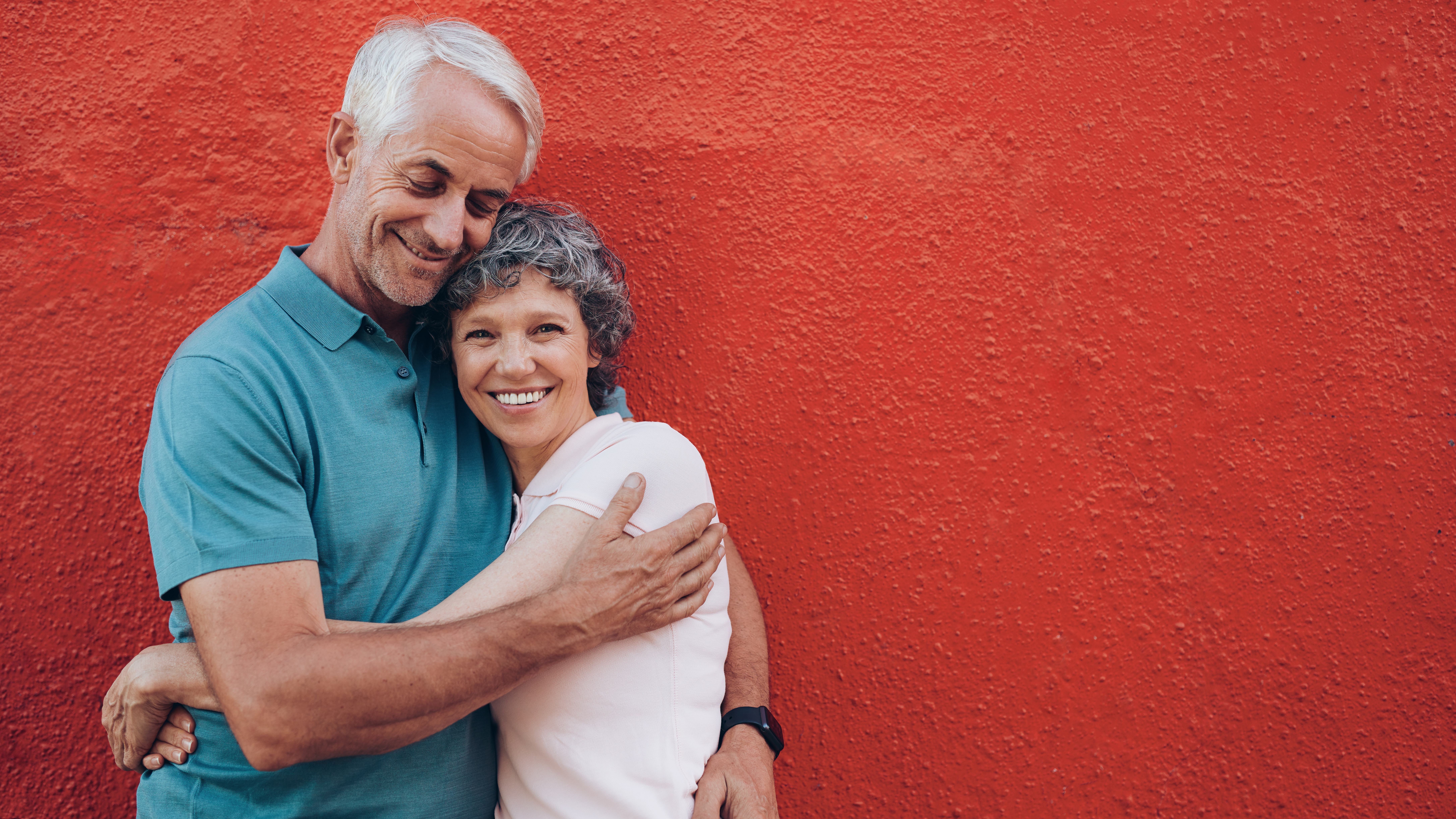 Happy couple hugging on the red background